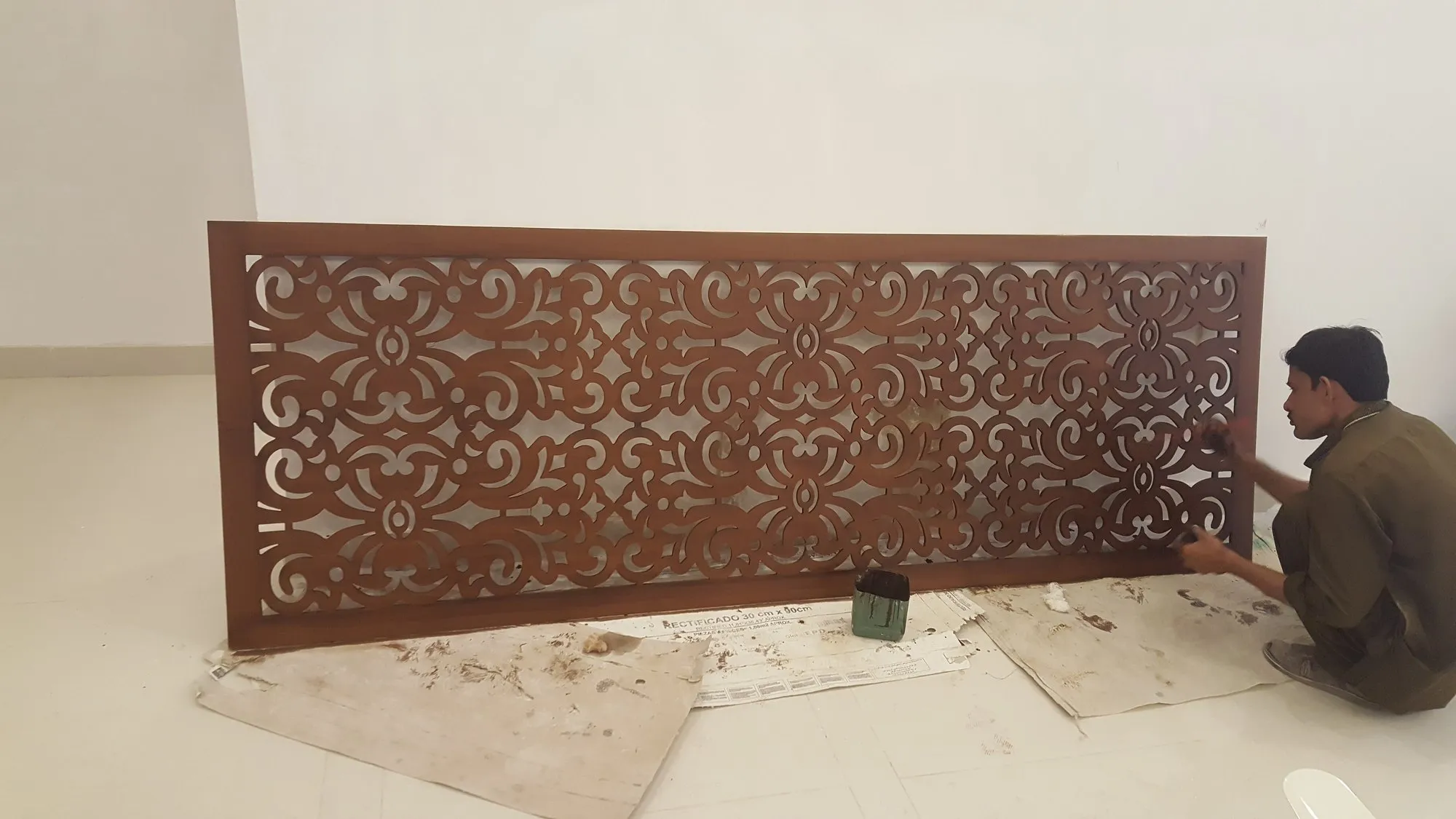 Craftsman finishing a carved timber jali screen in the Al-Saeed Enterprises joinery workshop, Karachi